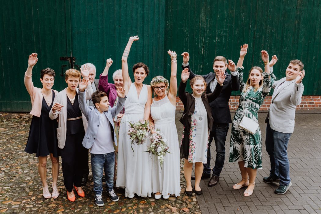 alt=“Zwei Bräute in Stade und Hamburg, Hochzeitsfotografin, Braut, Shooting auf dem Lande, Gay Couple, Weddingphotographer, Hochzeitsgesellschaft, Gruppenbilder“